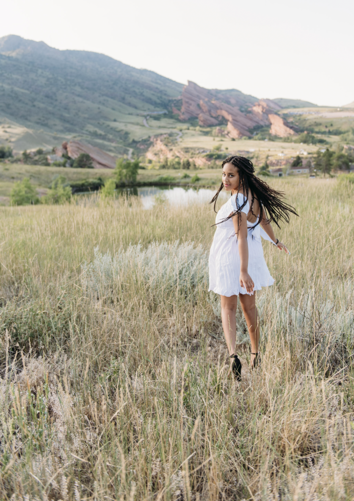 a senior girl twirls in a white dress. the joy of photographing seniors in denver 