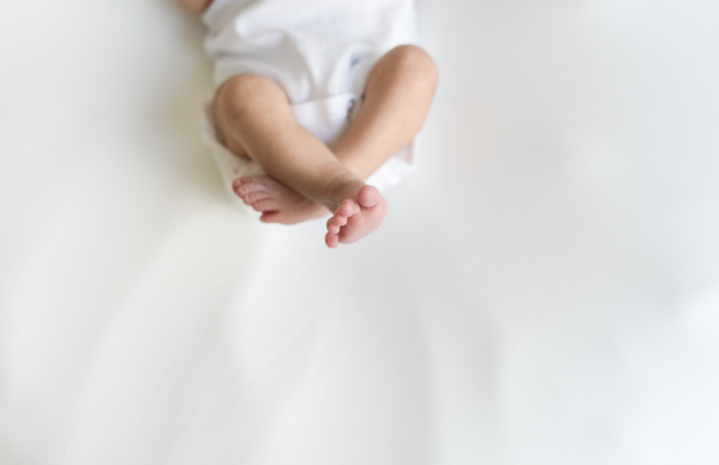 a newborns feet are photographed on a white backdrop
