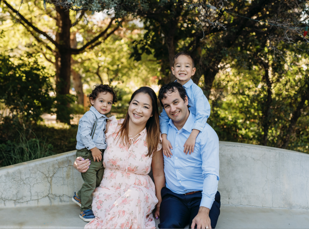 a family of four poses at the botanic gardens