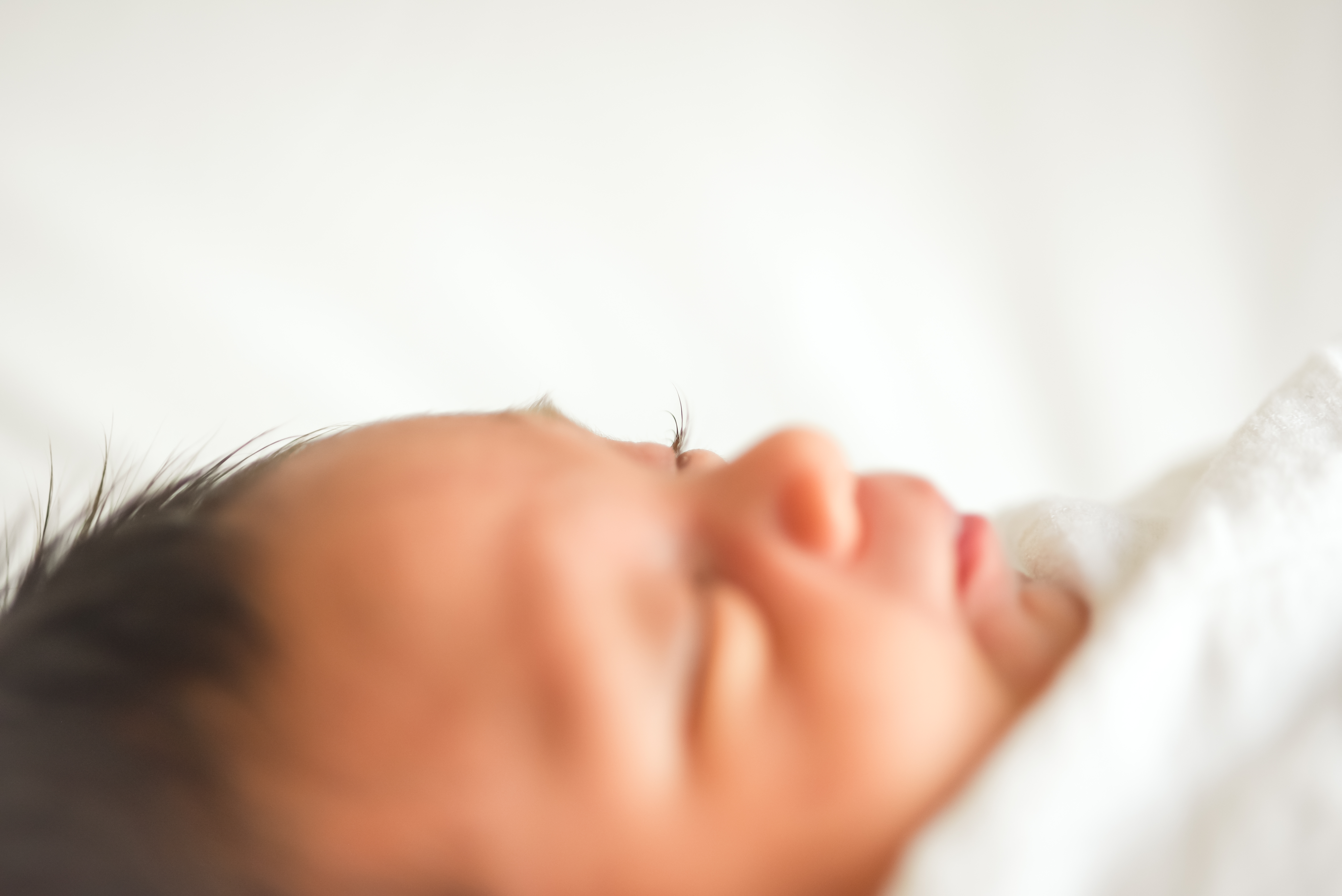a newborn rests while the focus in on her long eyelashes 