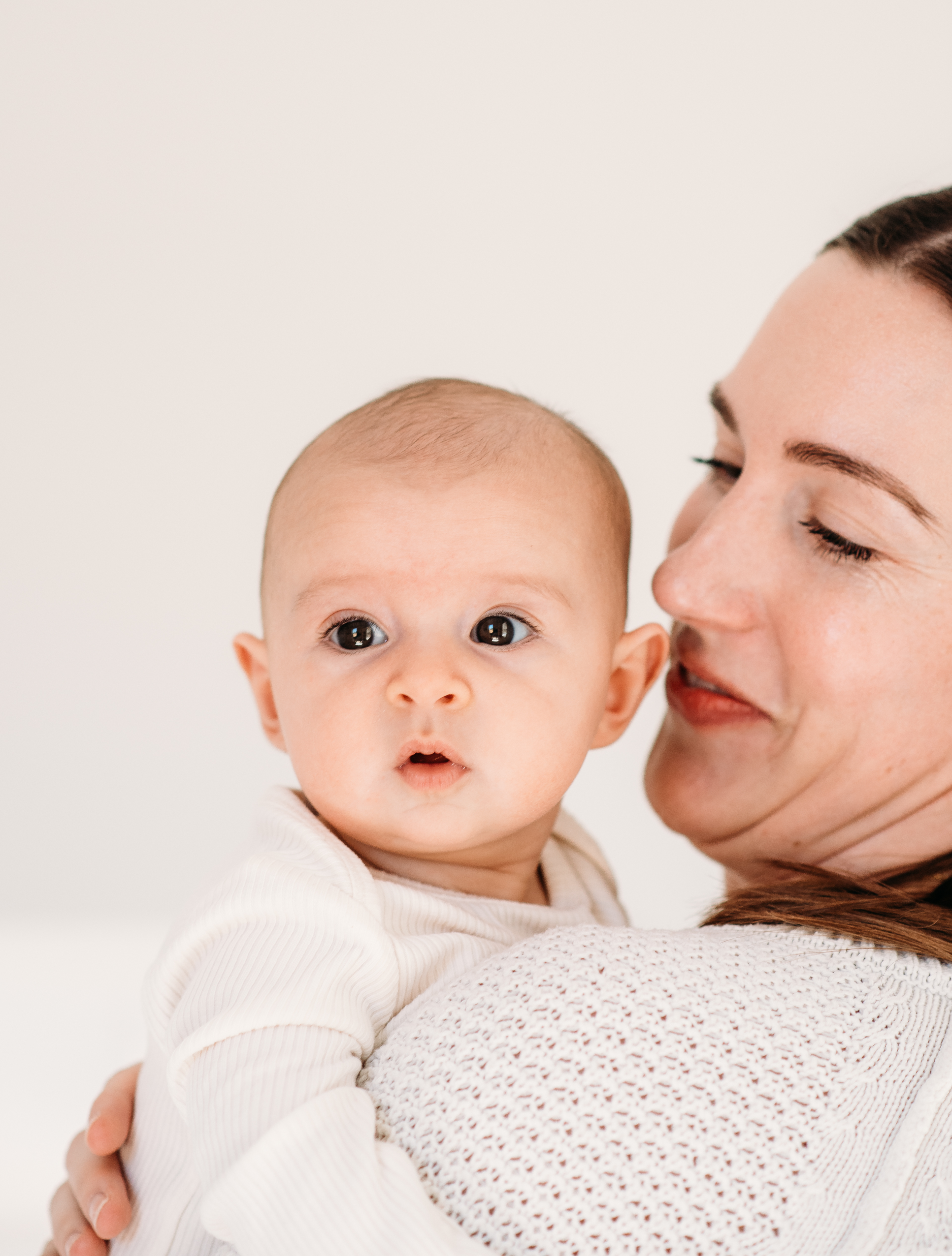 a new mom holds her baby close to her