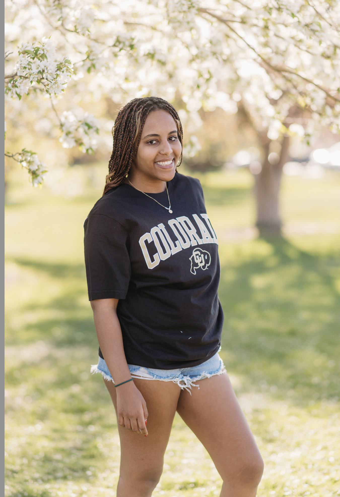 a senior girl poses with a colorado shirt