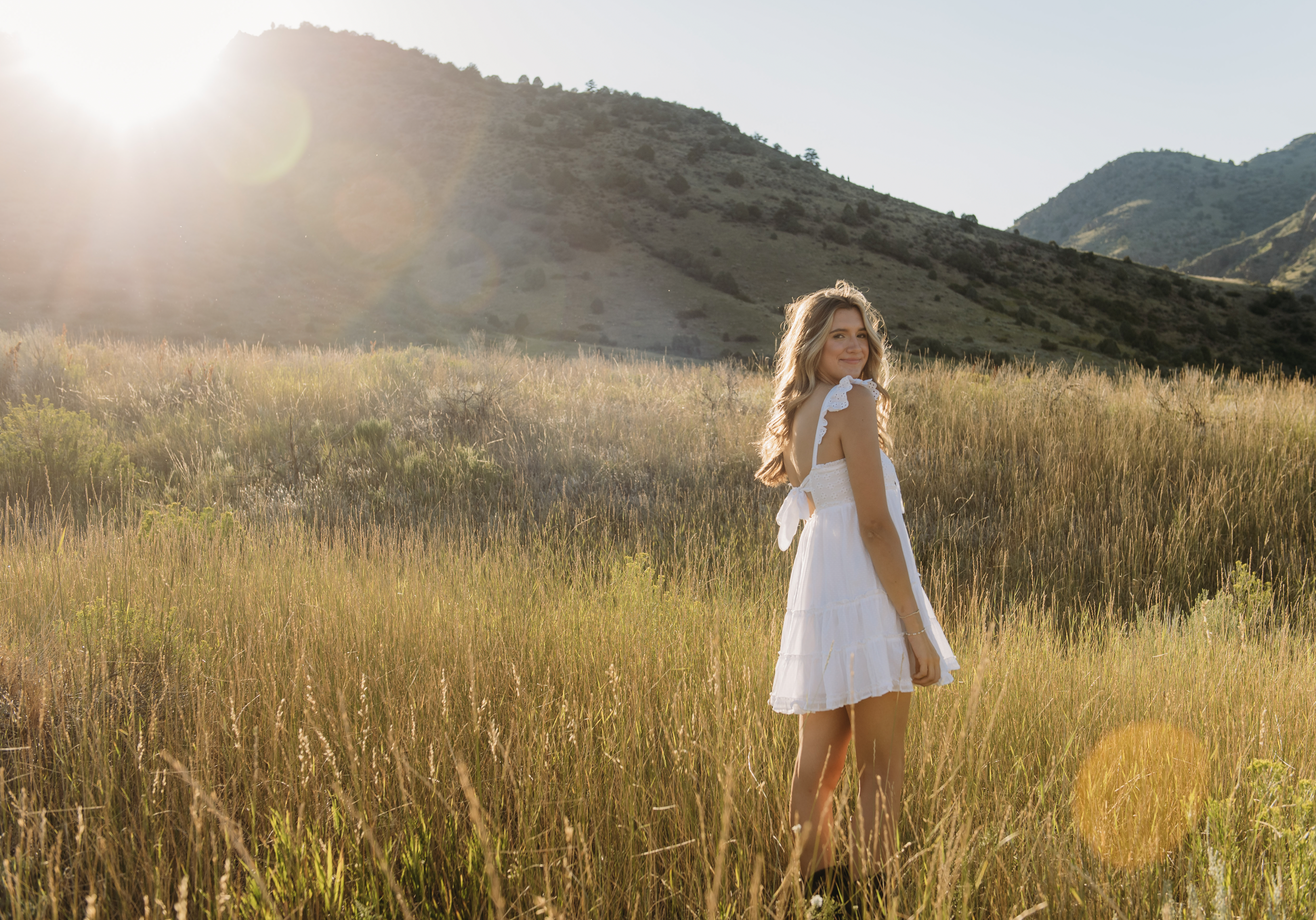 Screen Shot 2024-07-11 at 1.52.03 PM a senior girl poses in a field during golden hour